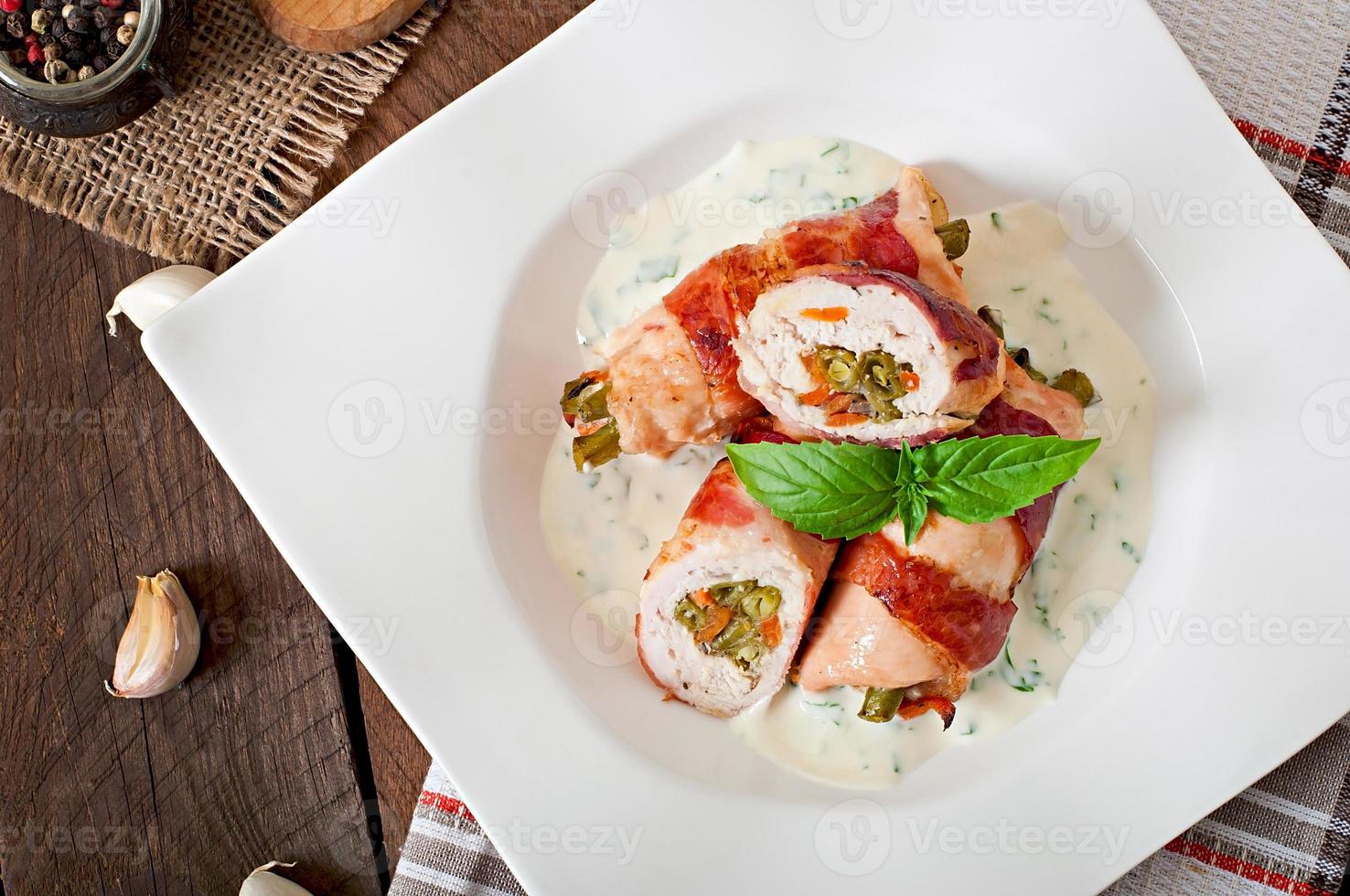 delizioso pollo rotoli ripieno con verde fagioli e carote avvolto nel strisce di Bacon foto