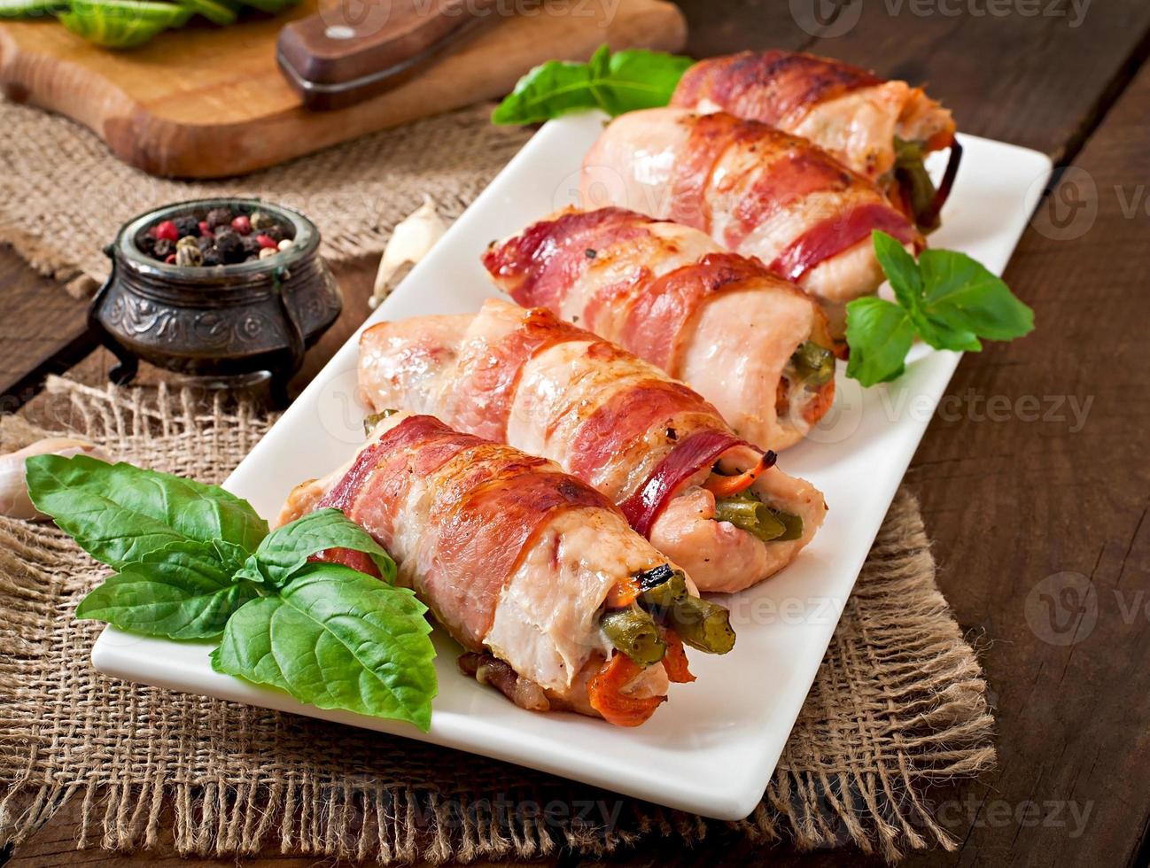 delizioso pollo rotoli ripieno con verde fagioli e carote avvolto nel strisce di Bacon foto