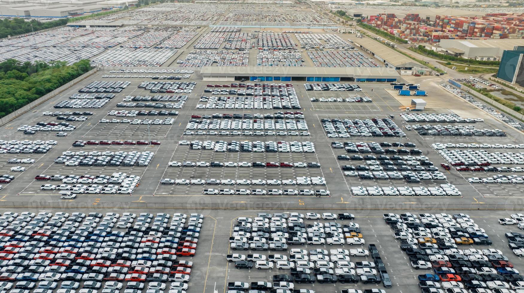 aereo Visualizza di nuovo macchine azione a fabbrica parcheggio quantità. sopra Visualizza molti macchine parcheggiata nel un' riga. settore automobilistico industria. la logistica e fornitura catena attività commerciale. importare o esportare nuovo macchine a magazzino vicino porta. foto