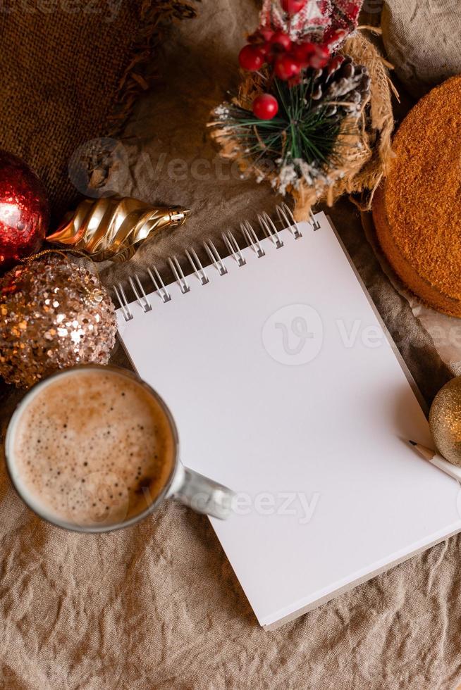 un' taccuino con vuoto pagine su un' di legno tavolo con caffè e fatti in casa miele torta. un' taccuino per ricette, cucinando a casa. fatti in casa torte, spazio per testo foto