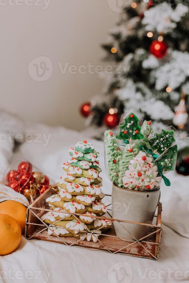 Natale dolci, Pan di zenzero dipinto con glassatura, Lecca-lecca e meringhe nel il forma di Natale alberi e mandarini su un' bellissimo vassoio. fatti in casa torte. delizioso cibo per il inverno vacanze foto