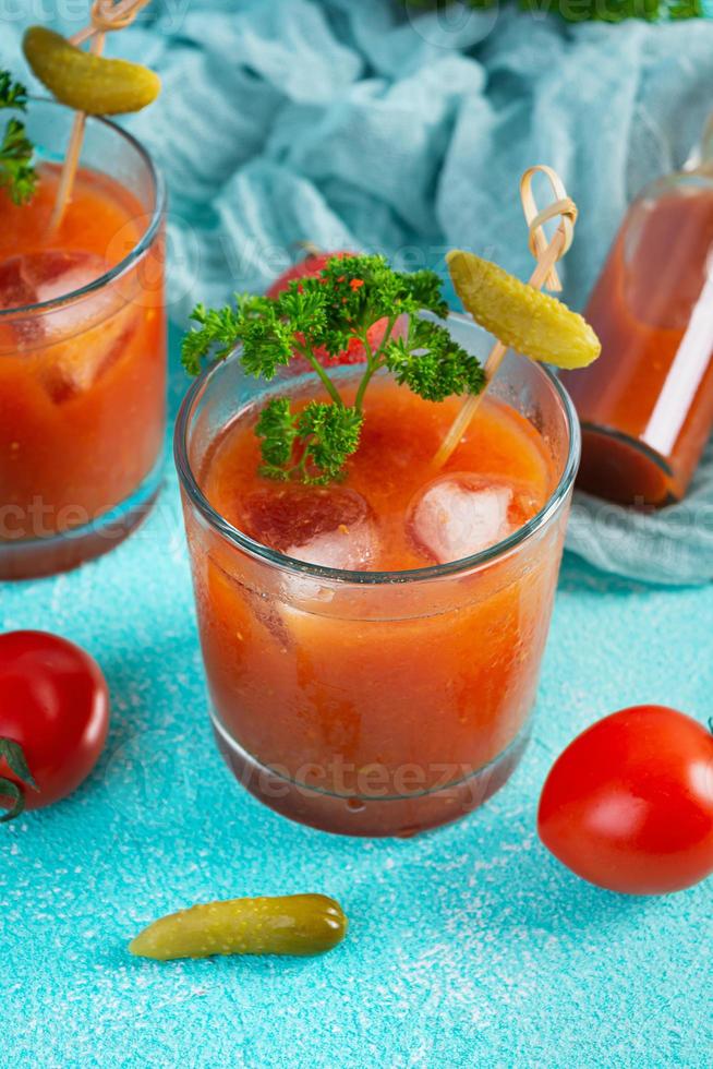 alcool cocktail sanguinoso Maria su blu sfondo. classico cocktail con pomodoro succo e Vodka foto