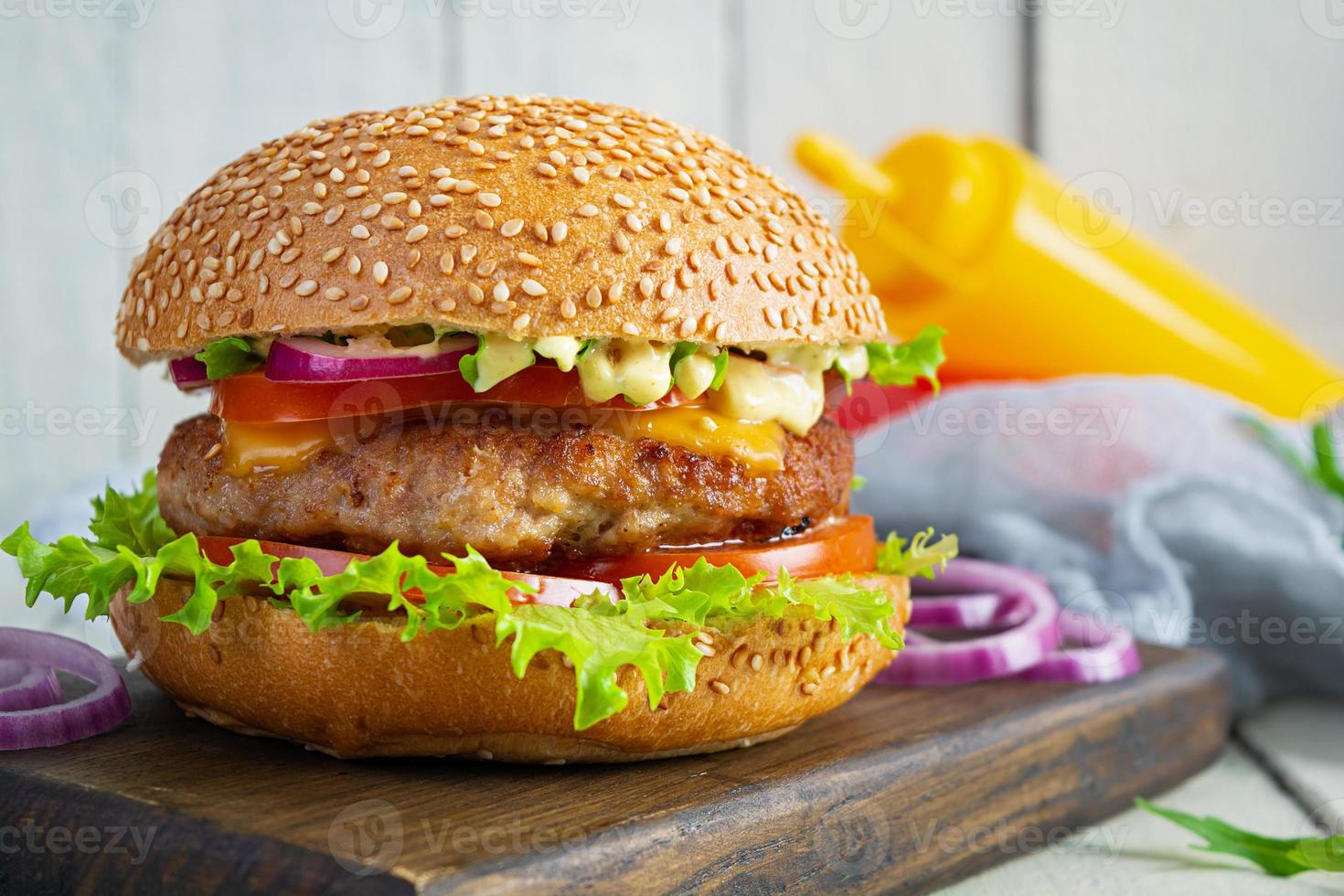 fatti in casa classico Hamburger con Manzo cotoletta, formaggio, lattuga e pomodoro su di legno sfondo foto