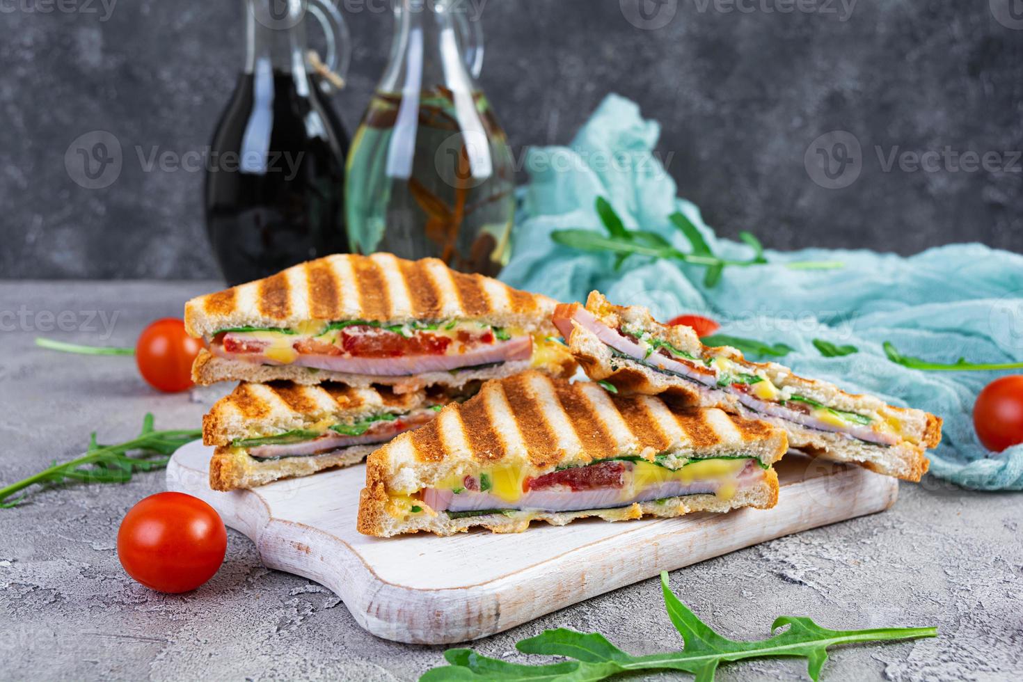 Sandwich con prosciutto, formaggio, mostarda foglie, pomodori e cipolla. gustoso club panini foto