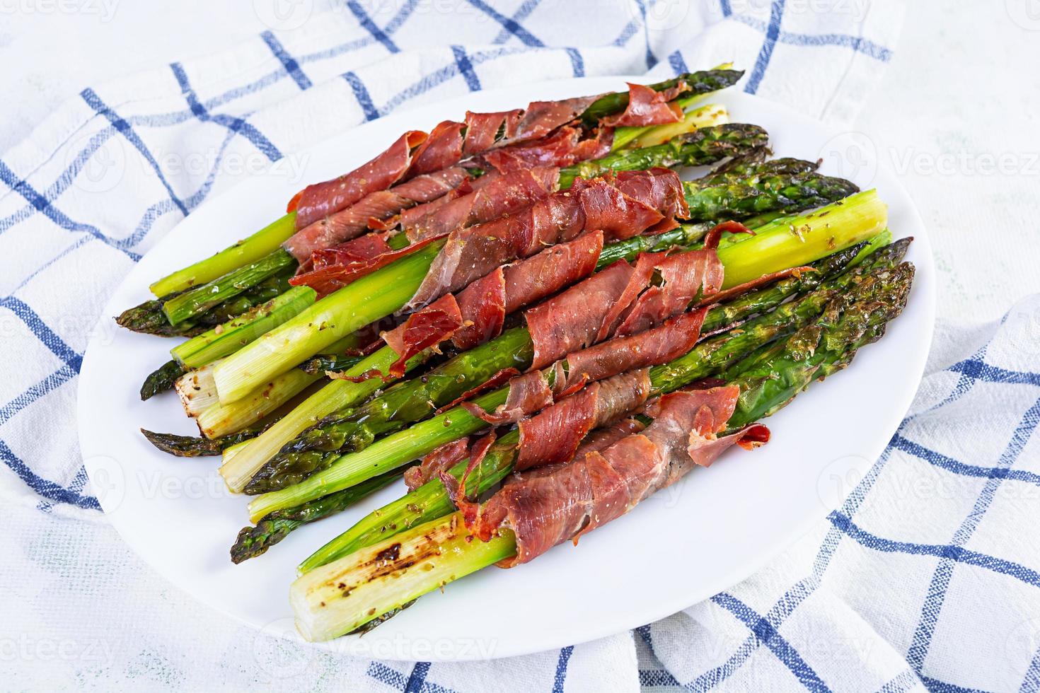 al forno asparago con Bacon e erbe aromatiche su di legno sfondo foto