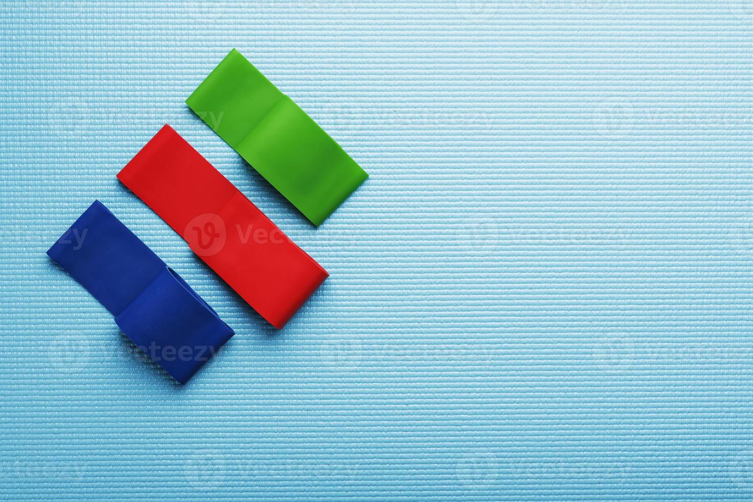 fitness elastico bande di diverso colori e carichi per gli sport su un' blu sfondo. foto