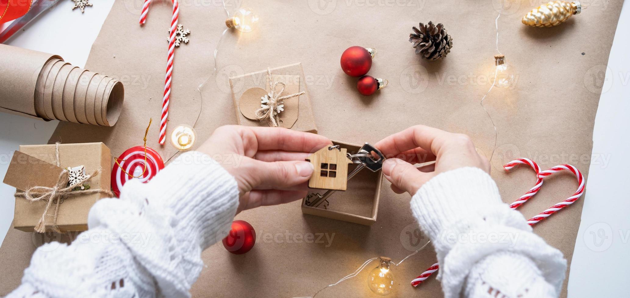 chiave per Casa con portachiavi su accogliente casa nel regalo scatola con Natale arredamento confezione. imballare presente per nuovo anno, Natale. costruzione, progetto, in movimento per nuovo Casa, mutuo, affitto, Acquista vero tenuta foto