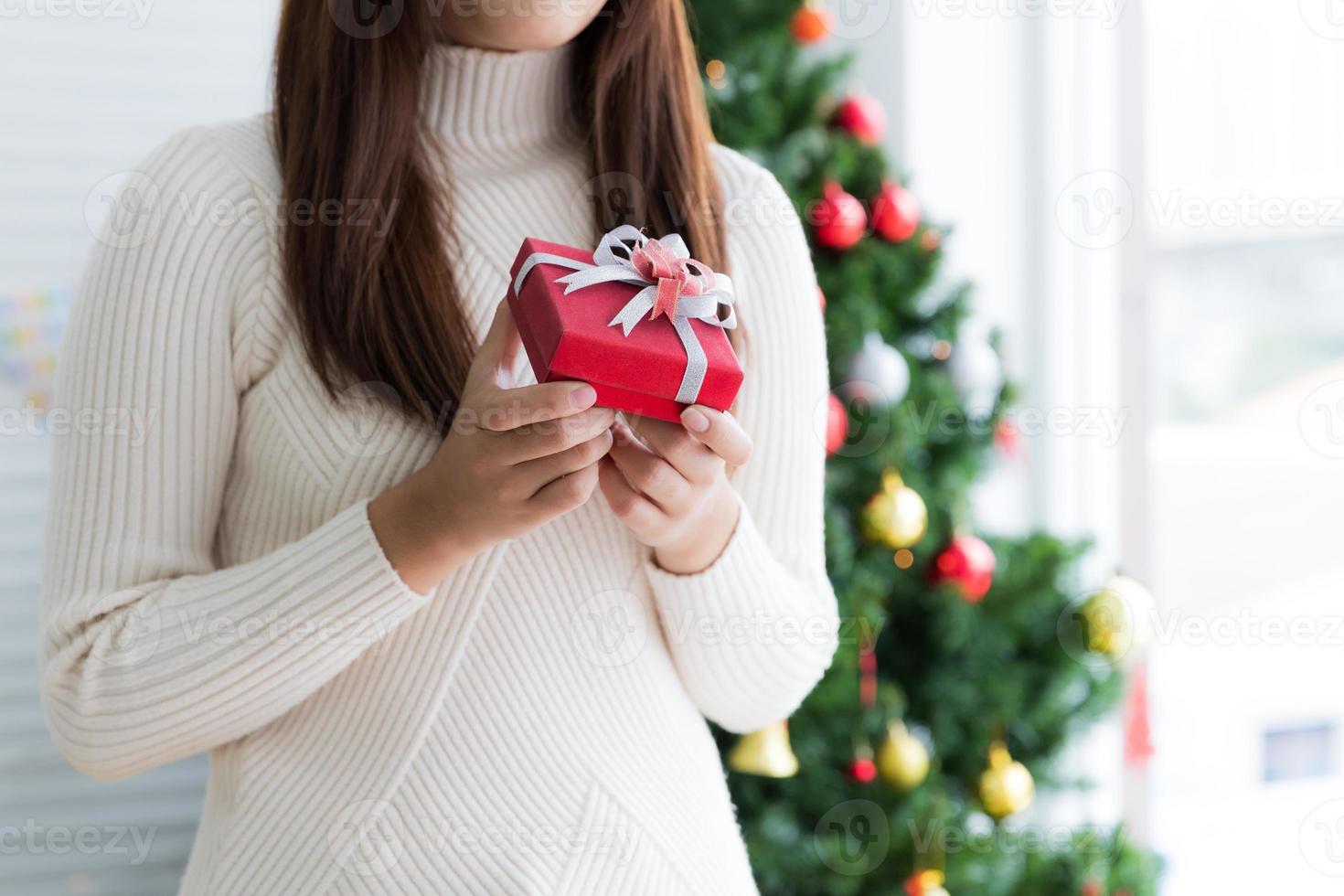 donna nel maglione Tenere rosso piccolo regalo scatola al di sopra di bianca sfondo foto