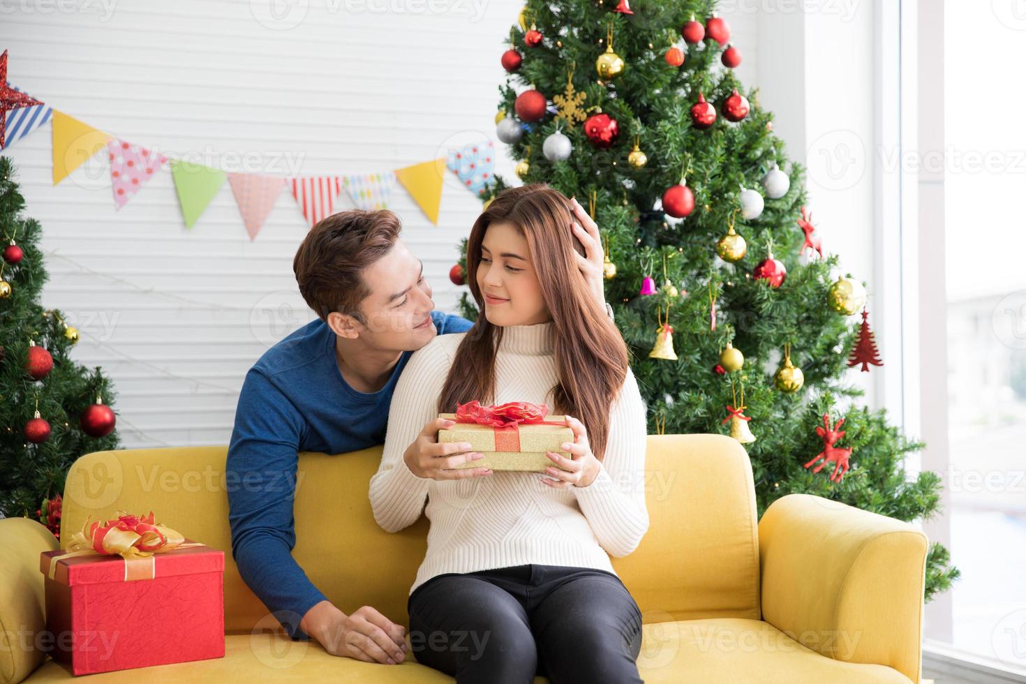 uomo dare donne i regali e mostrare loro amore con un' abbraccio su il donna di testa a Natale e nuovo anno giorno. foto