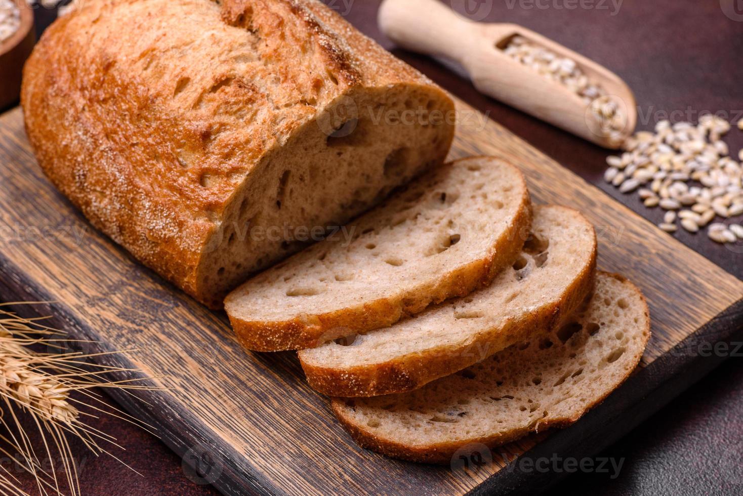 un' pagnotta di Marrone pane con cereali di cereali su un' di legno taglio tavola foto