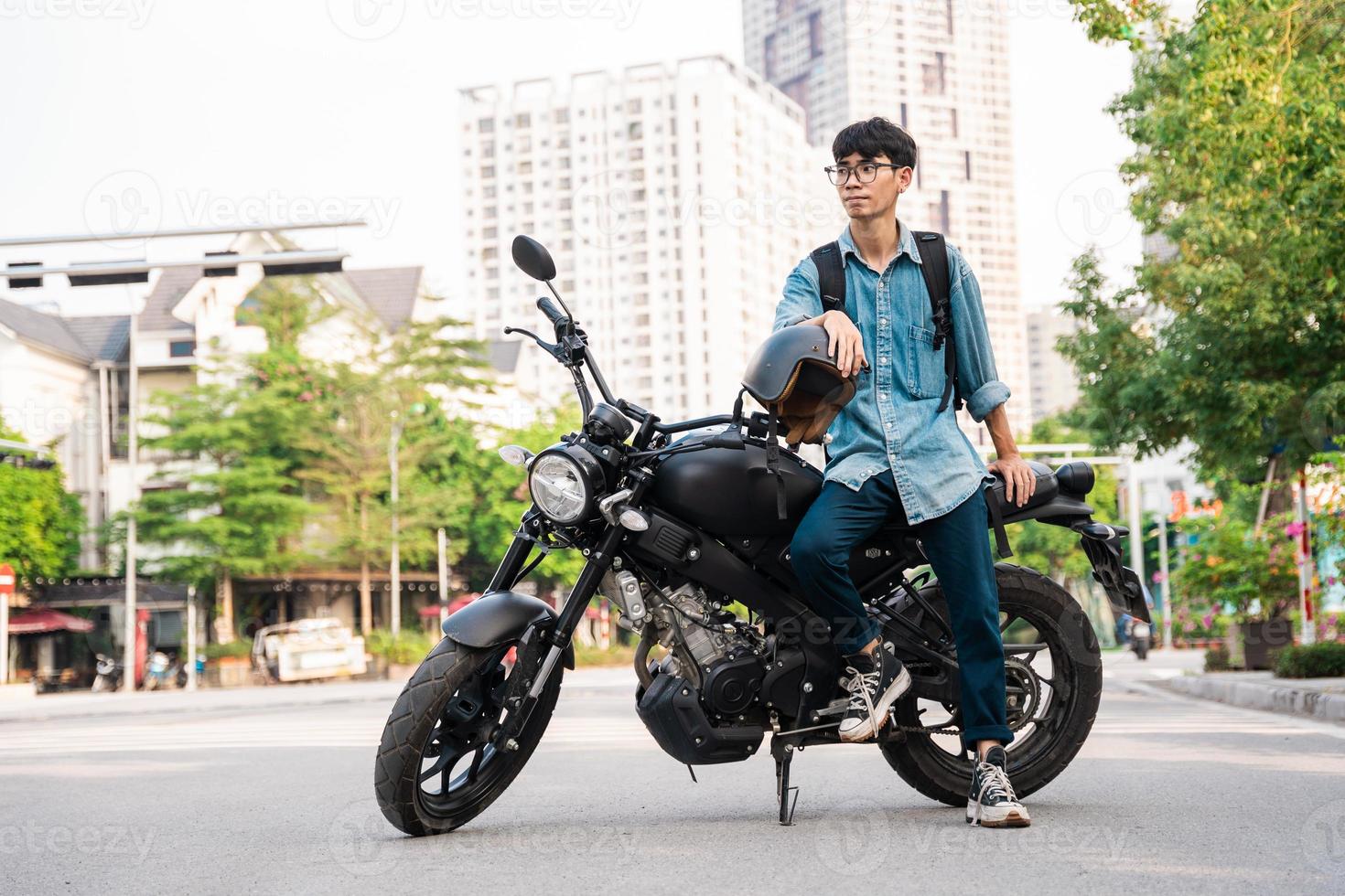 Immagine di asiatico uomo seduta su il suo motociclo foto