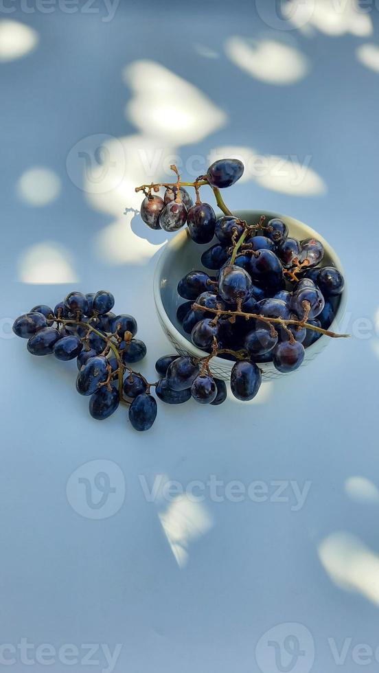 alto angolo, viola uva nel ciotola con gambo isolato su bianca sfondo e ombra 01 foto