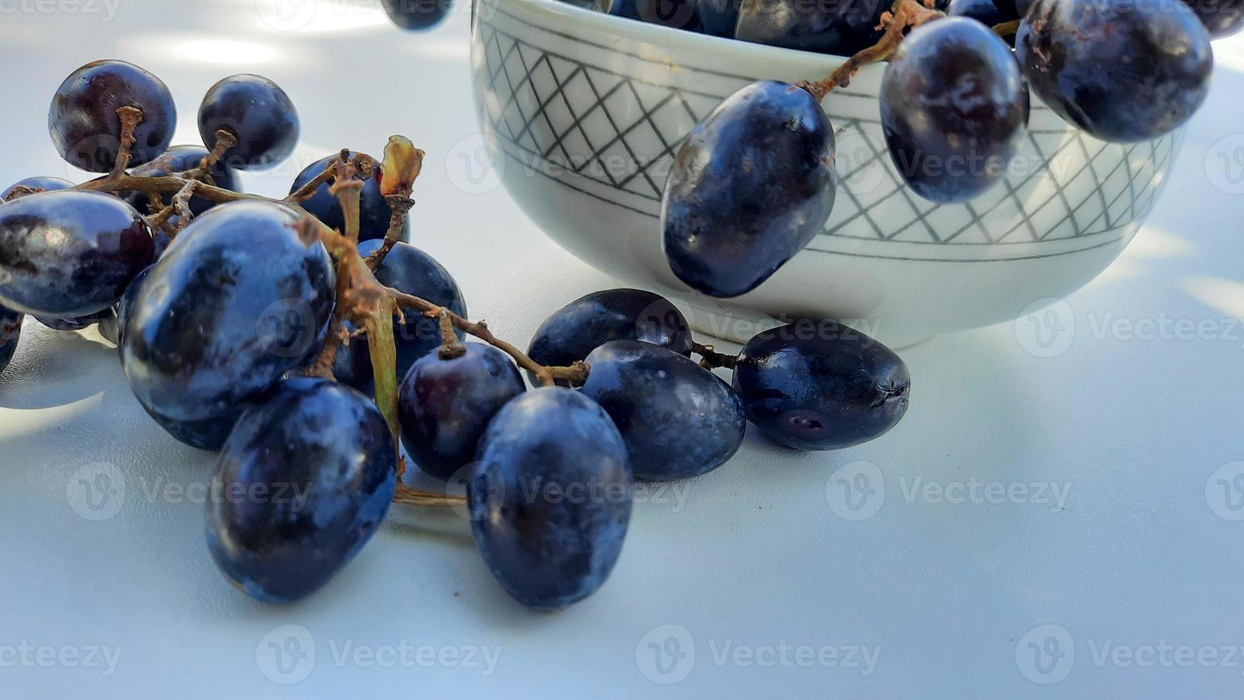 vicino su, viola uva nel ciotola con stelo isolato su bianca sfondo 01 foto