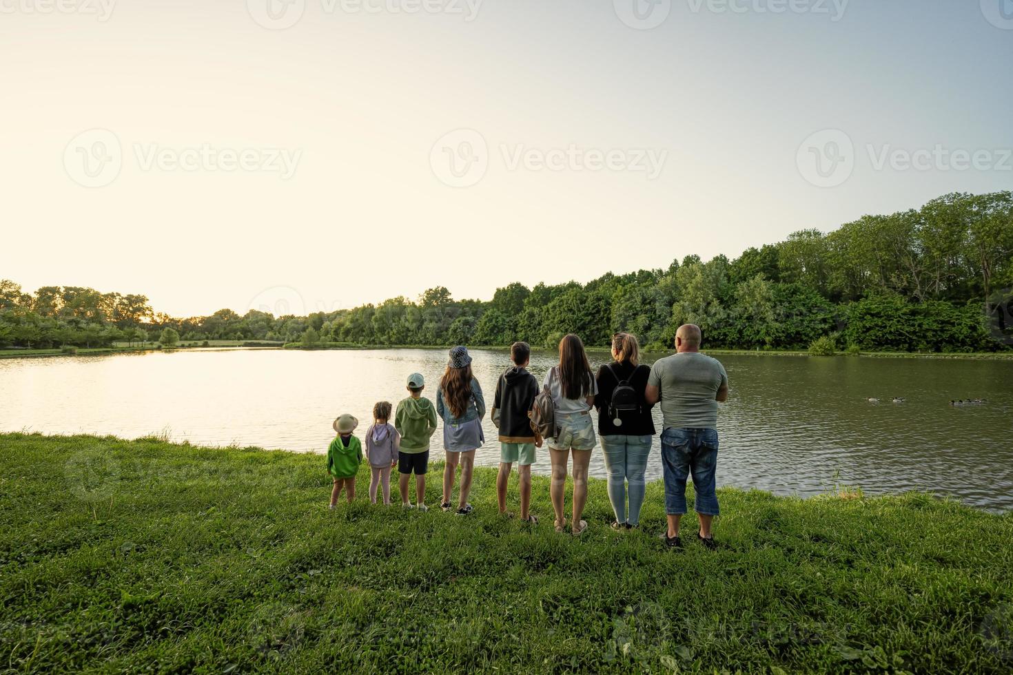 grande e grande famiglia contro lago nel Alba. sei bambini. genitori e bambini. foto