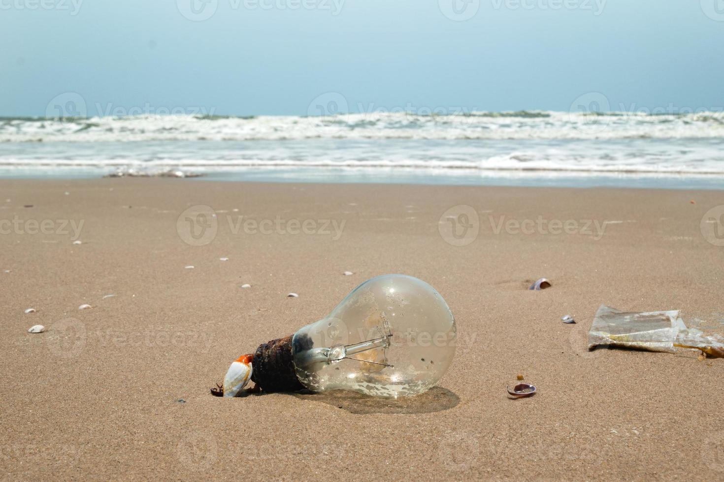vecchio leggero lampadina su un' sabbioso spiaggia vicino per il mare. inquinamento di un' costa. Vung tau, Vietnam. foto