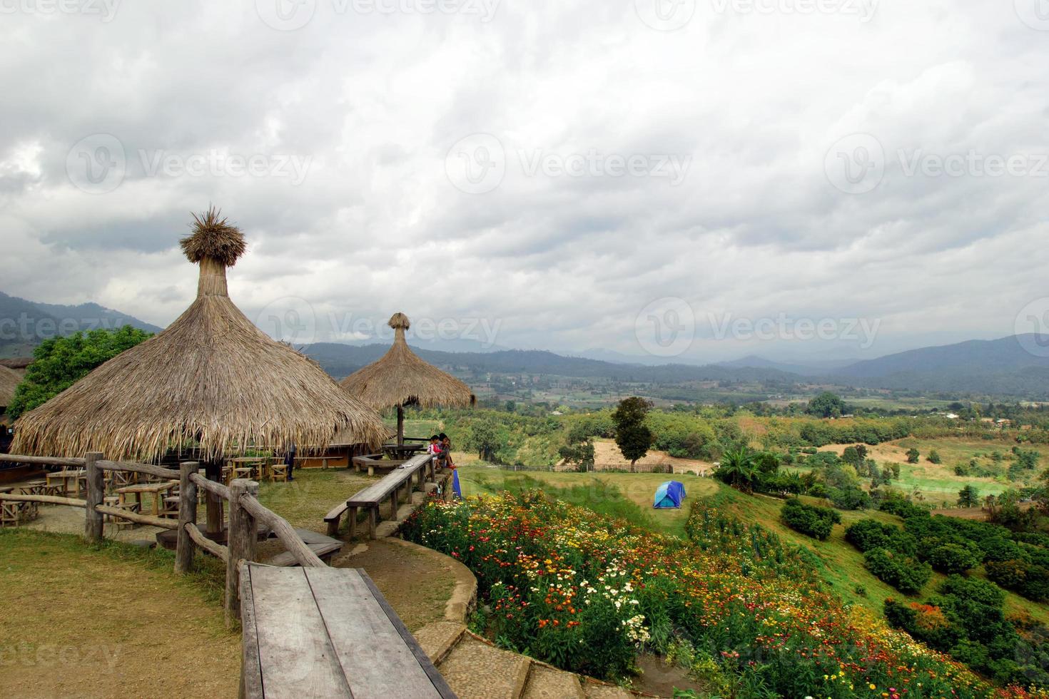 panoramico paesaggio su il montagne, piccolo villaggio, tende e un' campo di colorato crisantemi. yun lai, pai, Tailandia. foto
