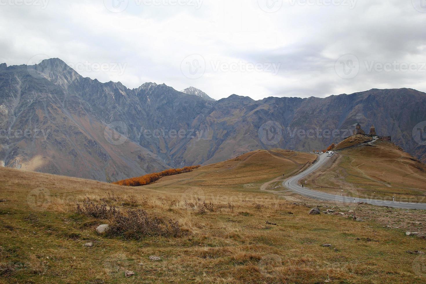 colorato autunno paesaggio con gergeti Trinità Chiesa su un' sfondo di Caucaso montagne, Georgia. foto