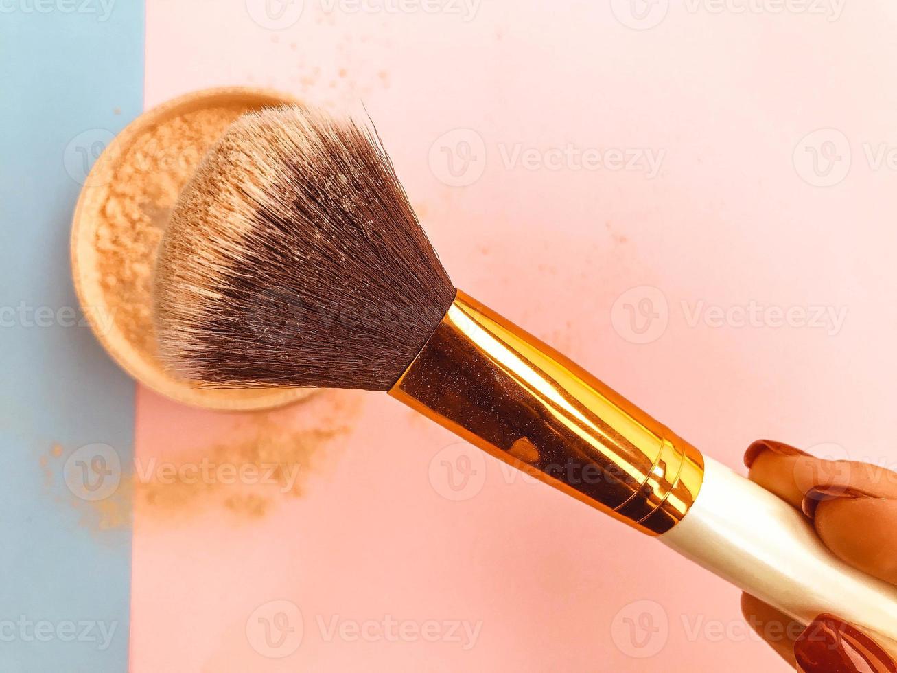 bellissimo alla moda bellezza cosmetico affascinante vaso con polvere e un' spazzola per l'applicazione trucco su il viso su un' blu e rosa dolce sfondo foto