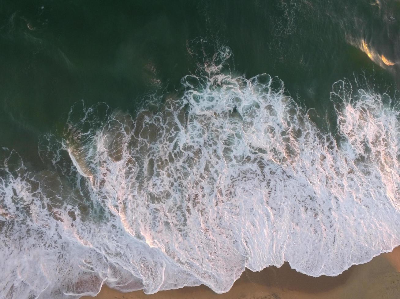 onde del mare che si infrangono sulla riva del mare foto