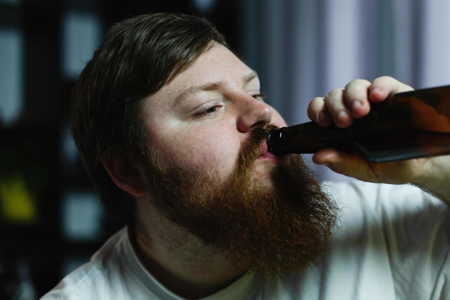 primo piano di un uomo che beve una birra foto