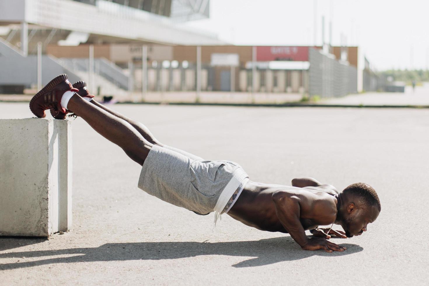 uomo afroamericano fa pus-up per strada durante il suo allenamento mattutino foto