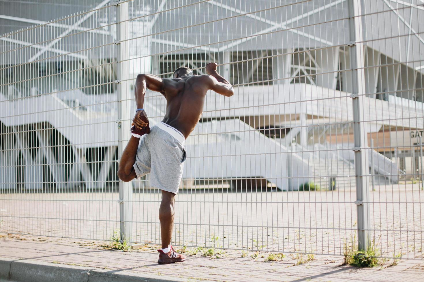 uomo che si estende prima di un allenamento foto