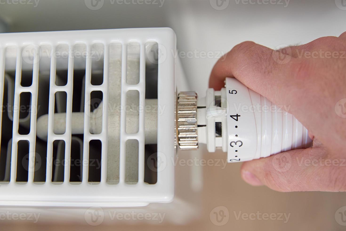 mano girare calore termosifone pomello termostato foto