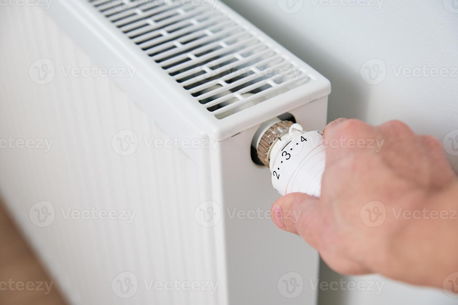 mano girare calore termosifone pomello termostato foto