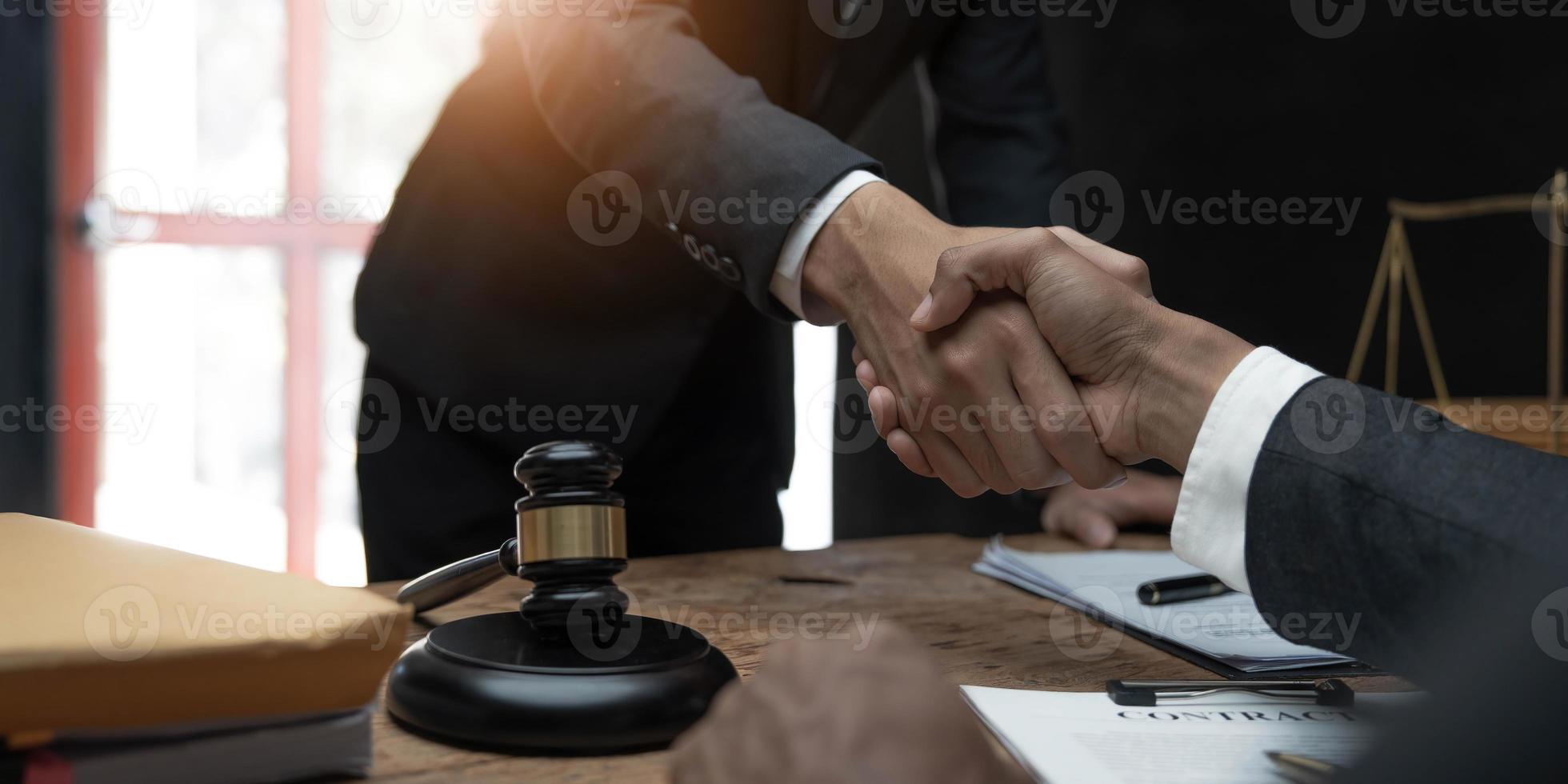 uomo d'affari che stringe la mano per sigillare un accordo con i suoi avvocati o avvocati partner che discutono di un accordo contrattuale. foto