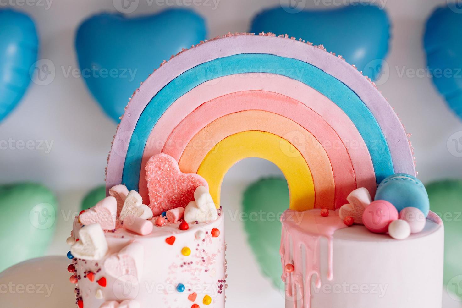 grande compleanno torta con arcobaleno, colorato spruzzatori. su molti colorato cuore palloncini sfondo. compleanno festa. dolce vacanza. foto