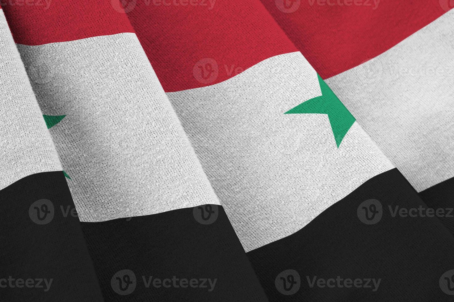 Siria bandiera con grande pieghe agitando vicino su sotto il studio leggero al chiuso. il ufficiale simboli e colori nel bandiera foto