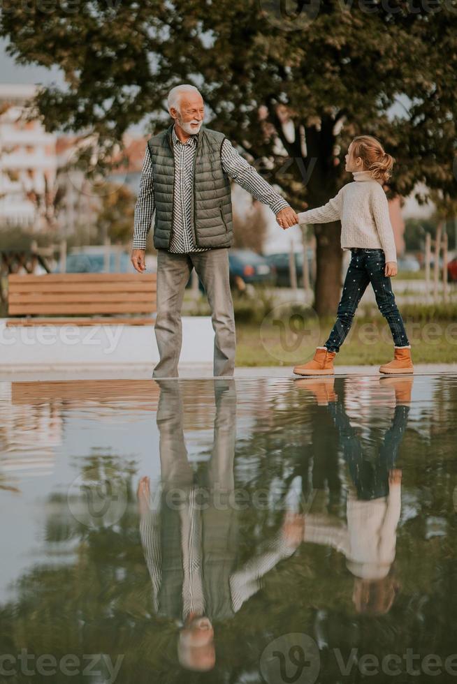 nonno la spesa tempo con il suo nipotina di piccolo acqua piscina nel parco su autunno giorno foto