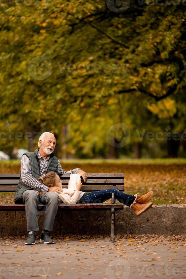 nonno la spesa tempo con il suo nipotina su panchina nel parco su autunno giorno foto