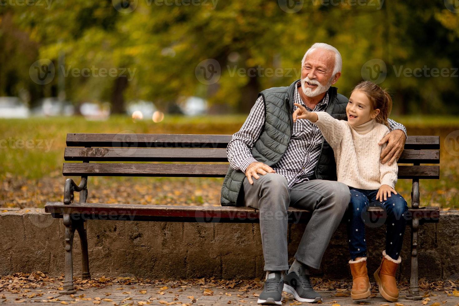 nonno la spesa tempo con il suo nipotina su panchina nel parco su autunno giorno foto