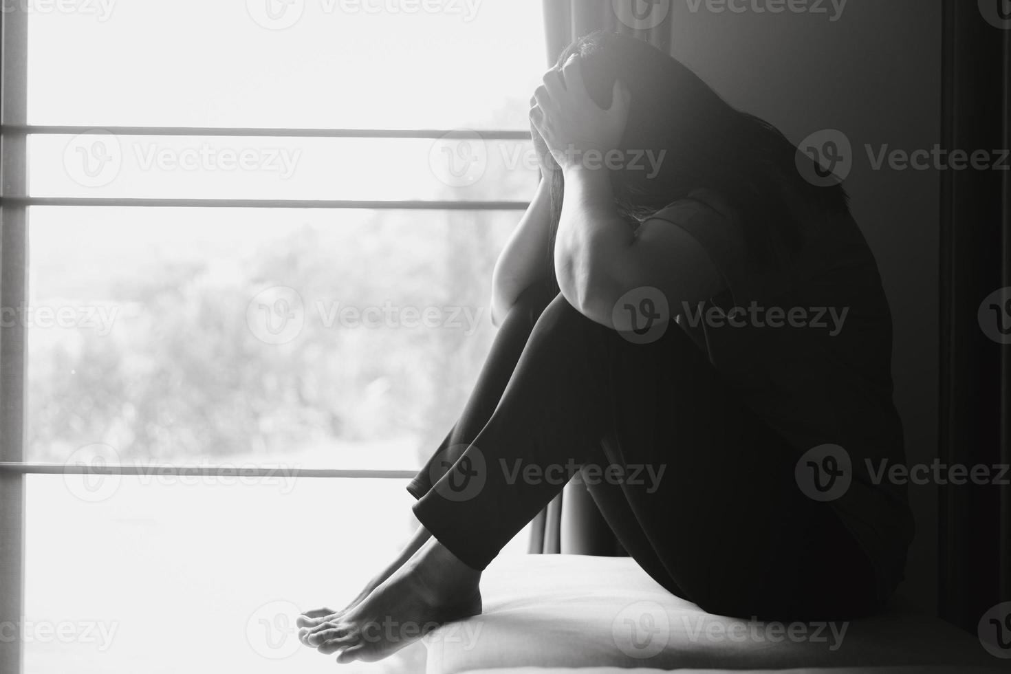 schizofrenia con solitario e triste nel mentale Salute depressione concetto. depresso donna seduta contro pavimento a casa con buio camera sensazione miserabile. donne siamo depresso, pauroso e infelice. foto