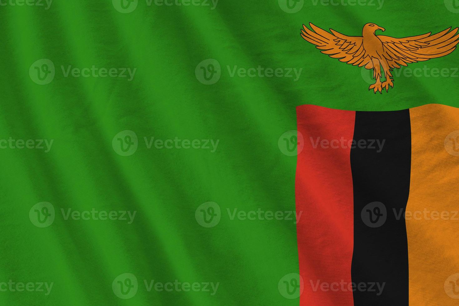 Zambia bandiera con grande pieghe agitando vicino su sotto il studio leggero al chiuso. il ufficiale simboli e colori nel bandiera foto