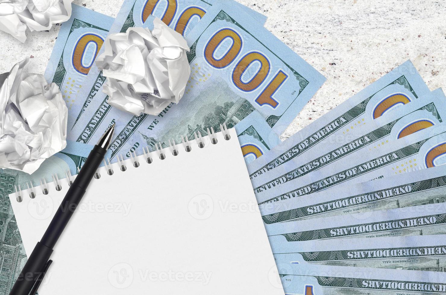 100 noi dollari fatture e palle di spiegazzato carta con vuoto bloc notes. cattivo idee o Di meno di ispirazione concetto. ricerca idee per investimento foto