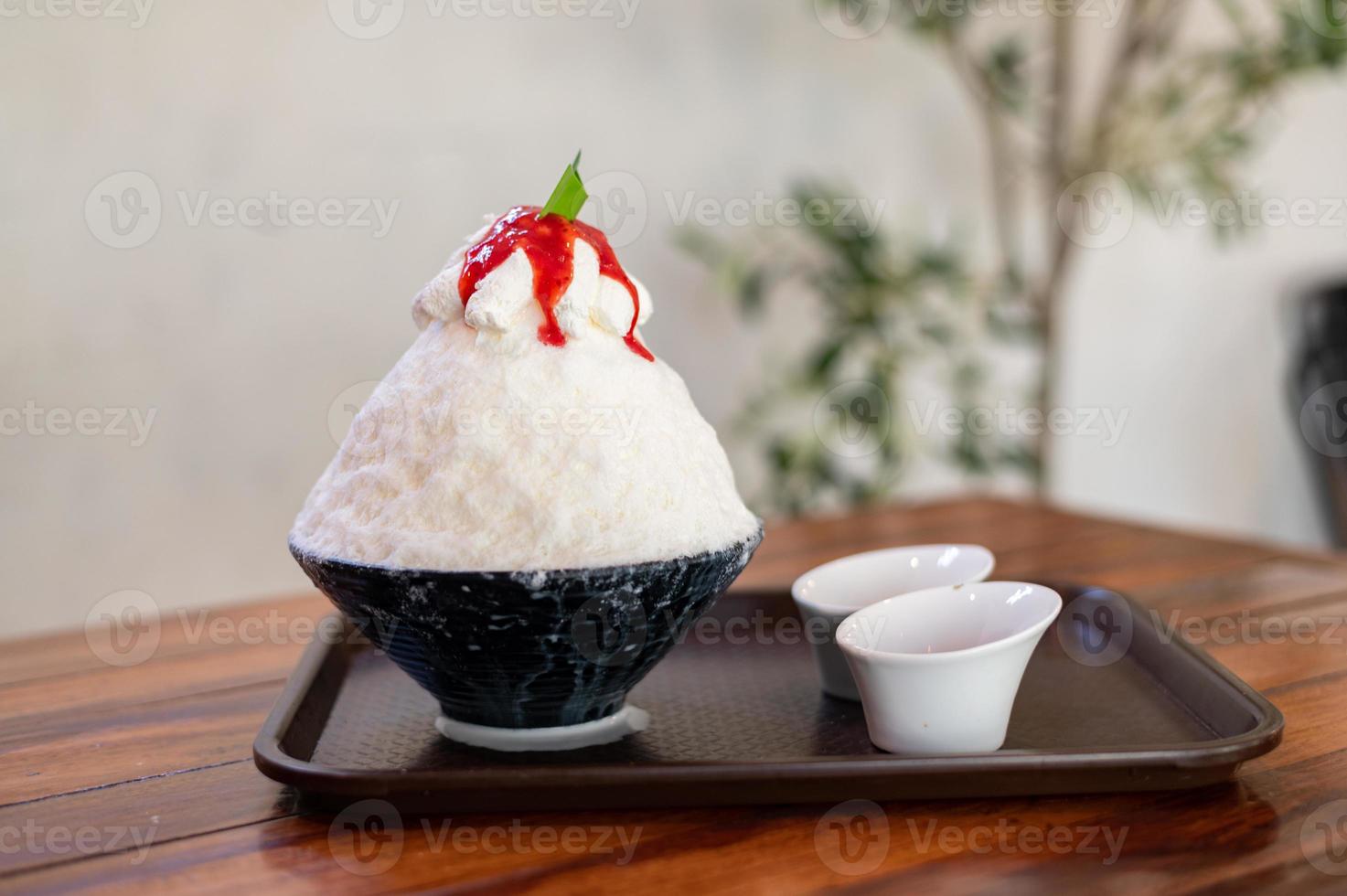 coreano rasato ghiaccio dolce con dolce condimenti, fragola bingsu su legna tavolo foto