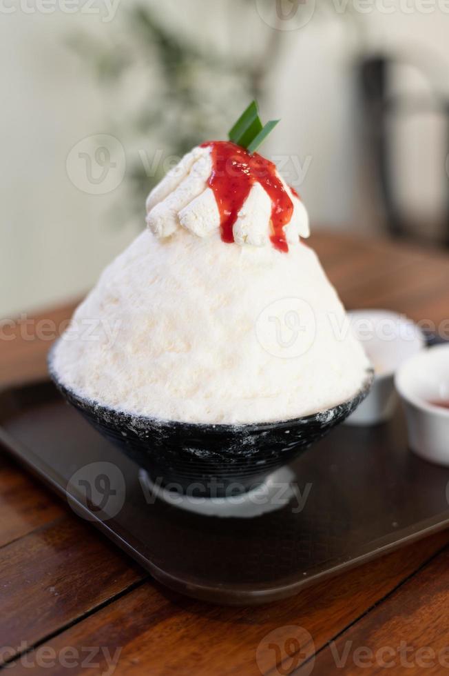 coreano rasato ghiaccio dolce con dolce condimenti, fragola bingsu su legna tavolo foto