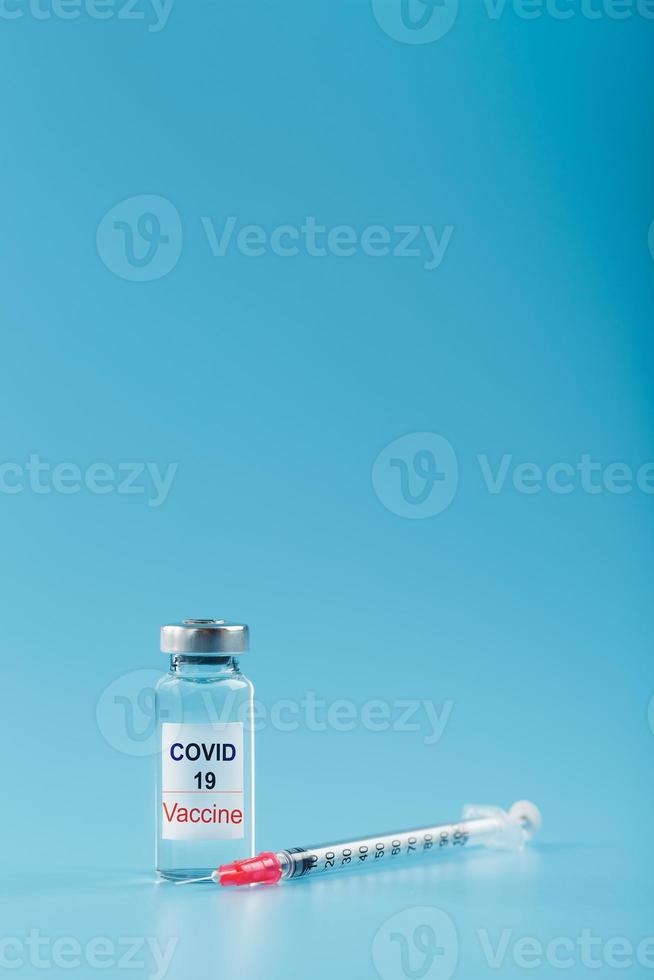 siringa e fiala con un' vaccino contro il covid-19 virus contro malattie su un' blu sfondo. foto