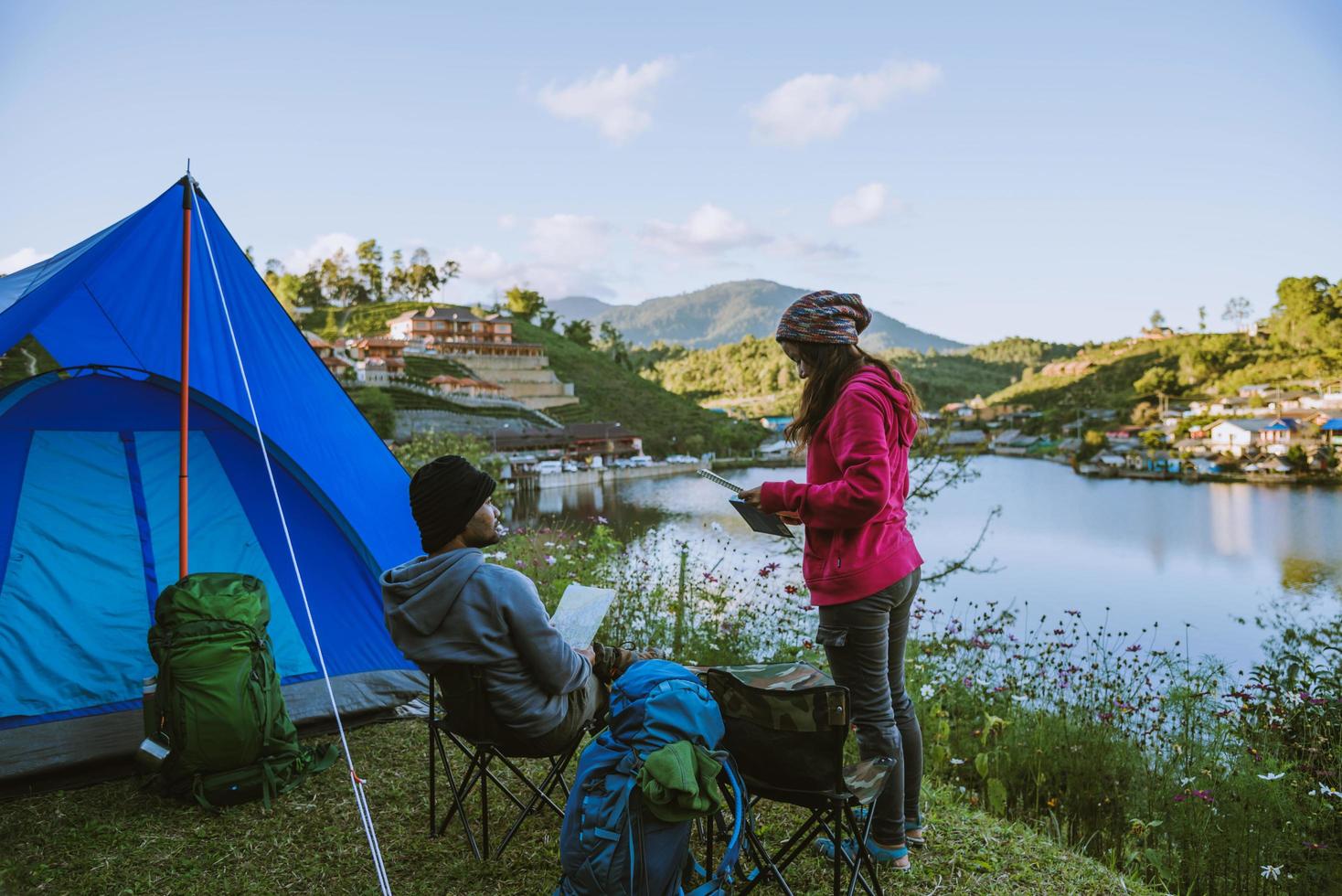 accampamento di coppia asiatica sulla montagna nel villaggio superiore vicino al lago, concetto di viaggio in campeggio, mappa concettuale di viaggio relax. foto