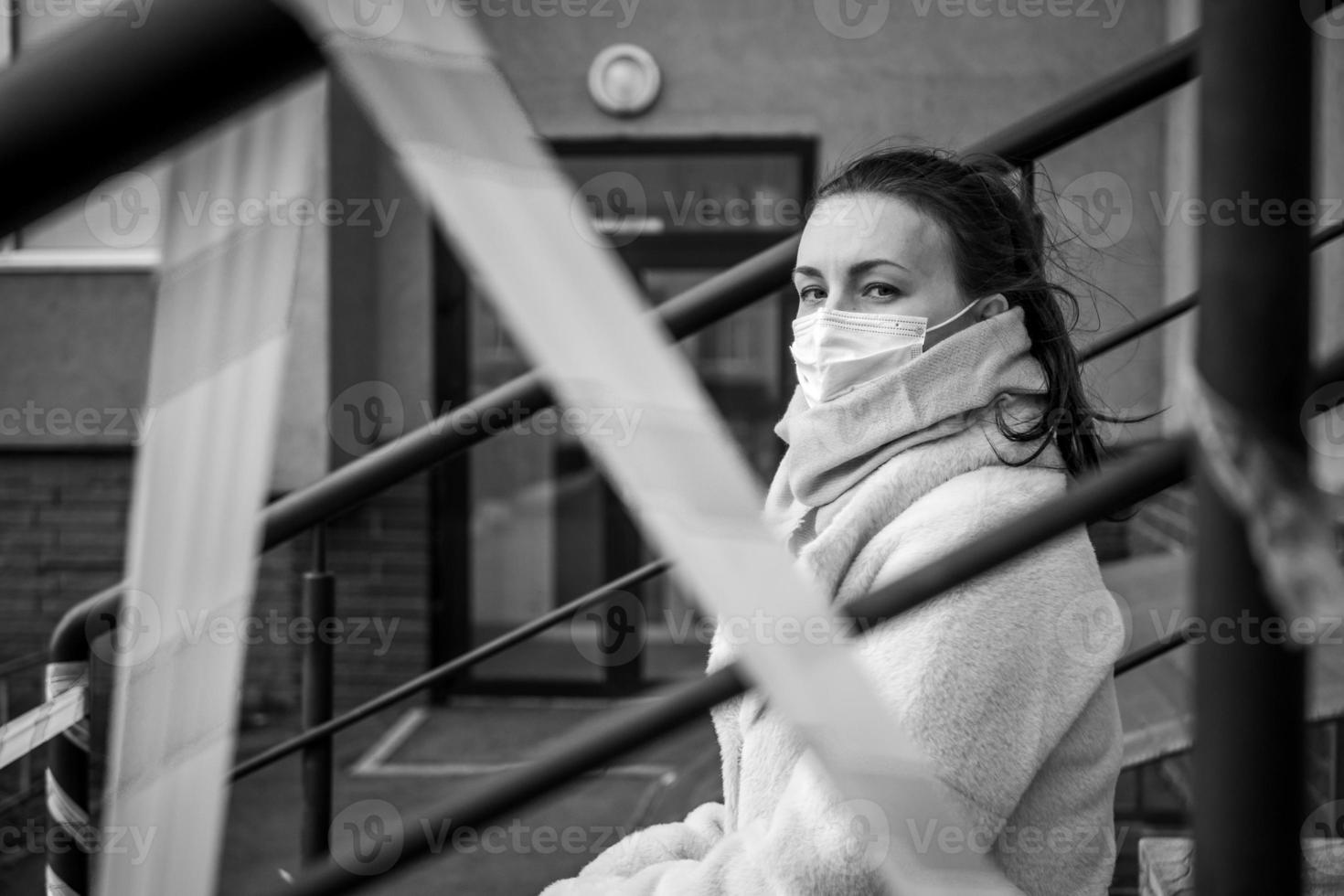 foto di un' ragazza nel un' maschera. seduta su il strada con Pericolo avvertimento nastri.