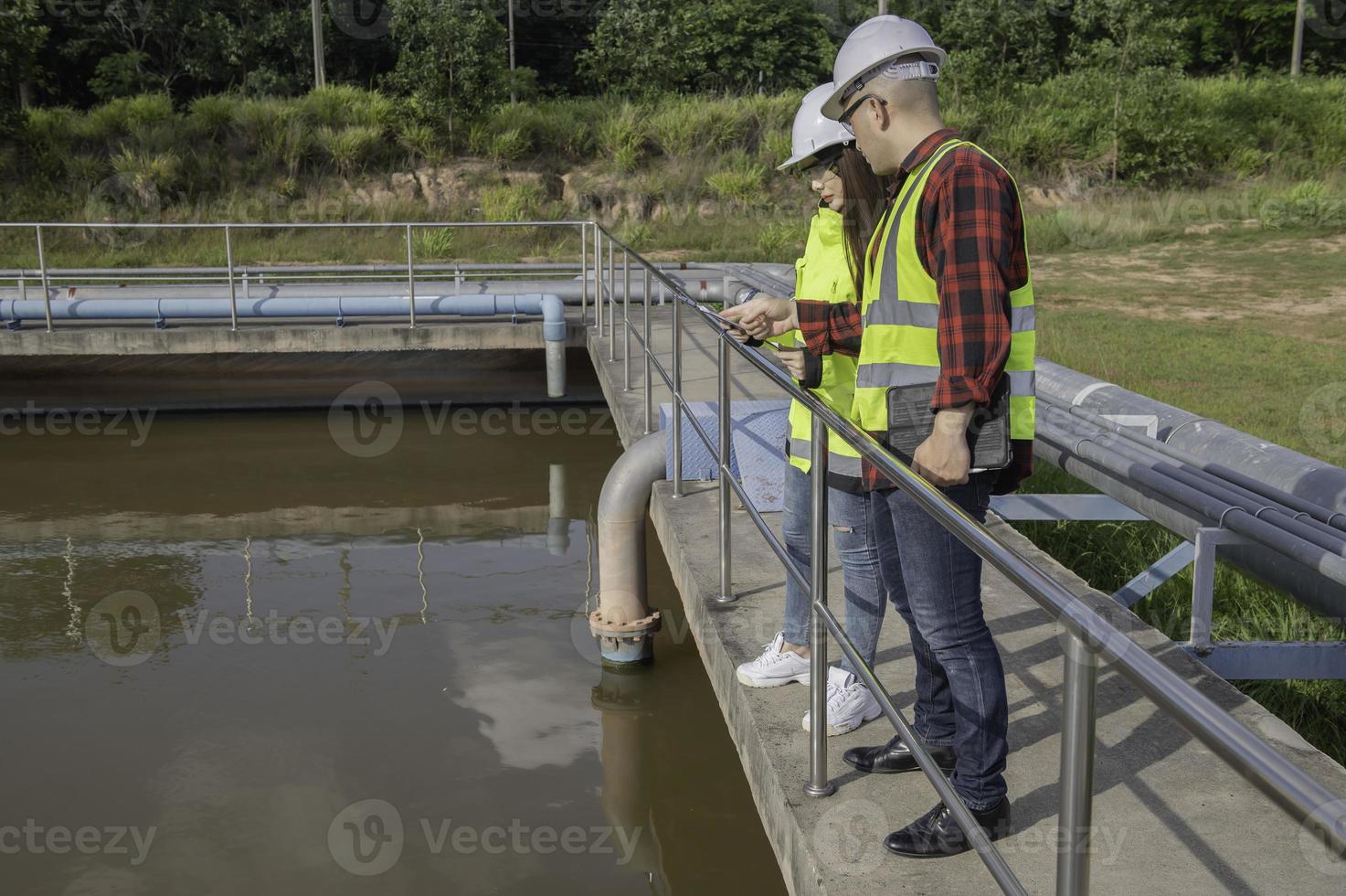 gli ingegneri ambientali lavorano presso gli impianti di trattamento delle acque reflue, l'ingegneria dell'approvvigionamento idrico lavora presso l'impianto di riciclaggio dell'acqua per il riutilizzo, i tecnici e gli ingegneri discutono del lavoro insieme. foto