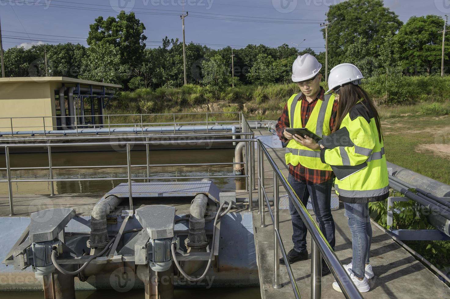 gli ingegneri ambientali lavorano presso gli impianti di trattamento delle acque reflue, l'ingegneria dell'approvvigionamento idrico lavora presso l'impianto di riciclaggio dell'acqua per il riutilizzo, i tecnici e gli ingegneri discutono del lavoro insieme. foto