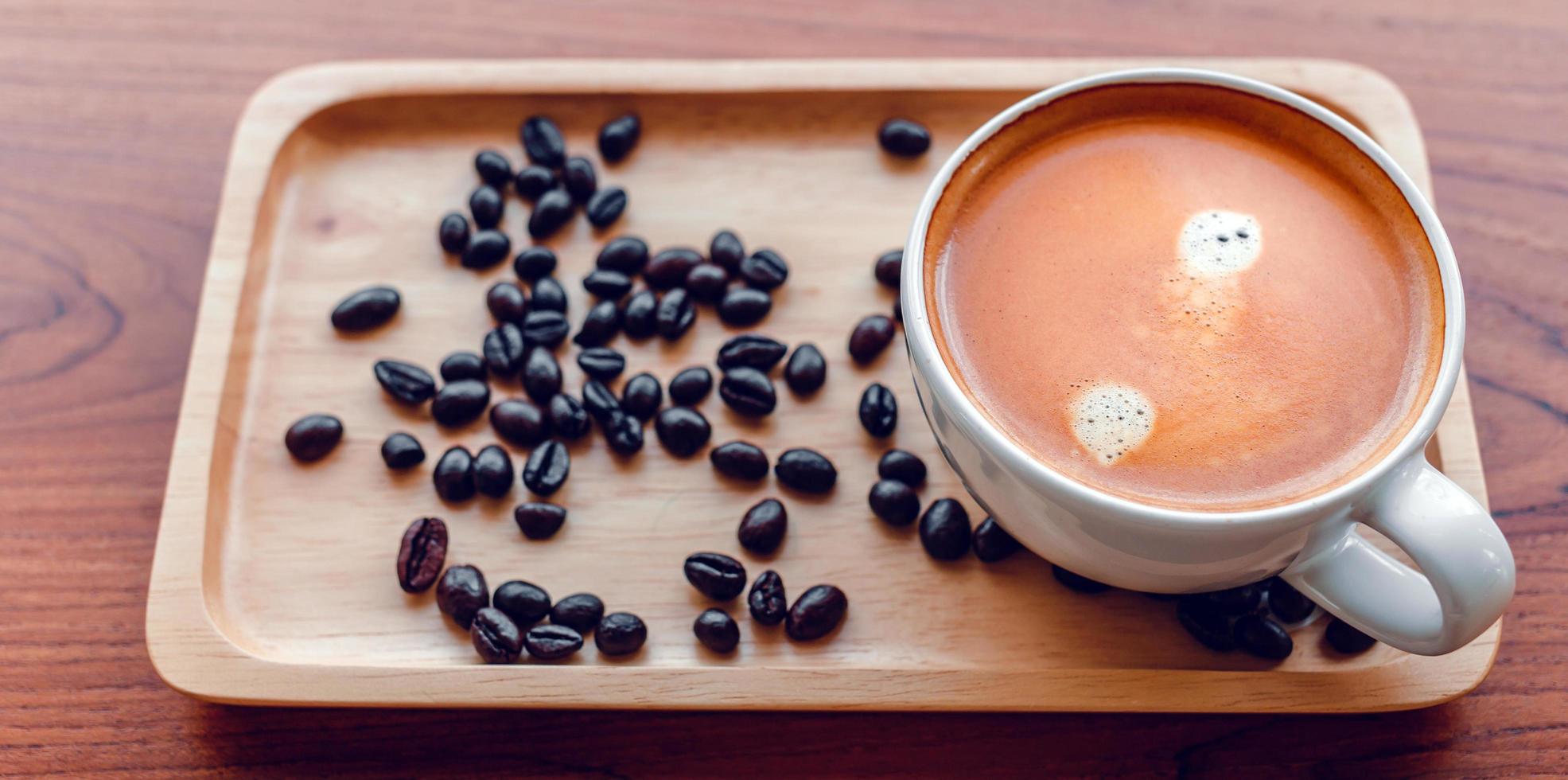 bianca tazza di caffè espresso caffè e arrostito caffè fagioli su un' di legno vassoio foto