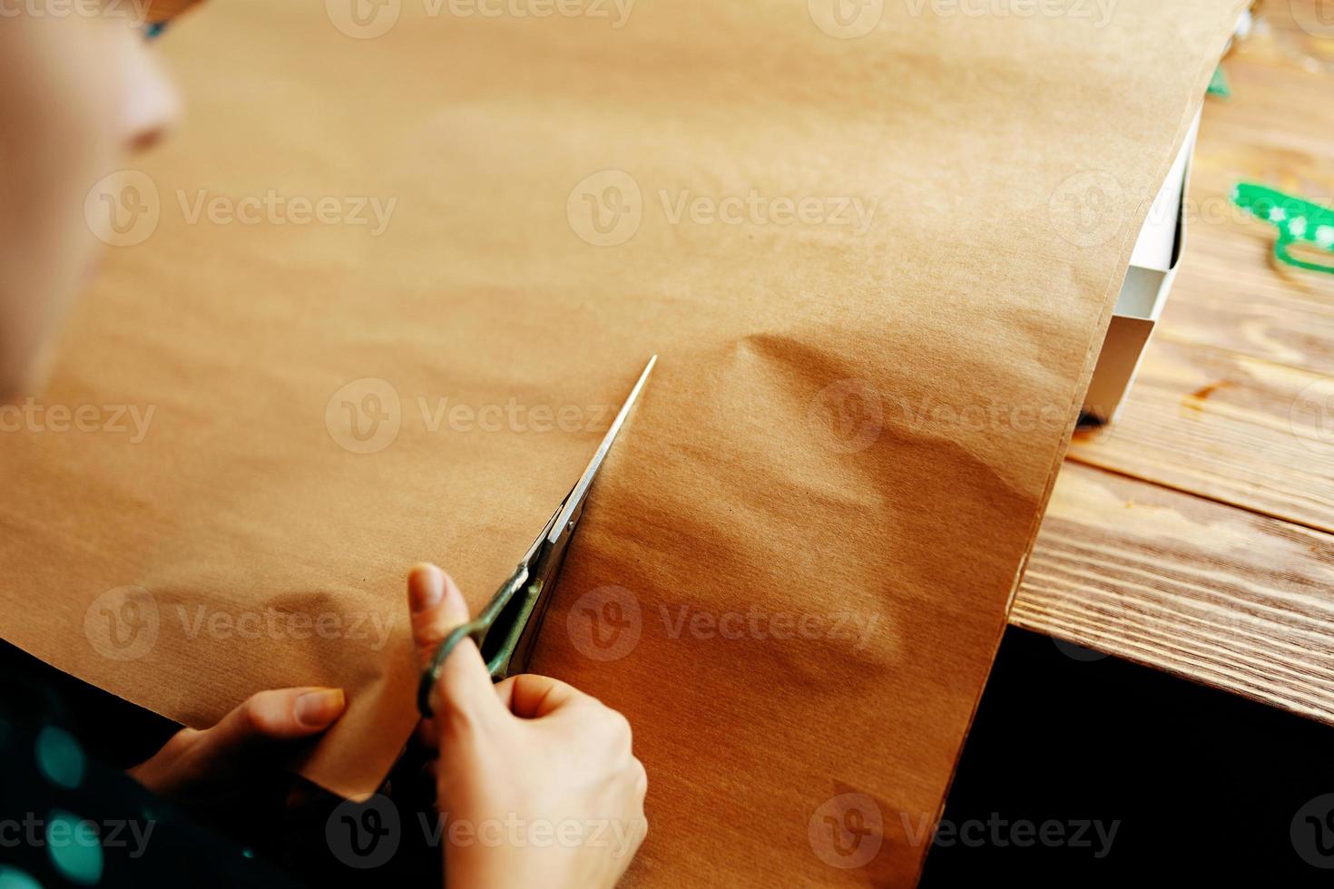 Da donna mani tagliare foglio di mestiere carta con forbici. foto