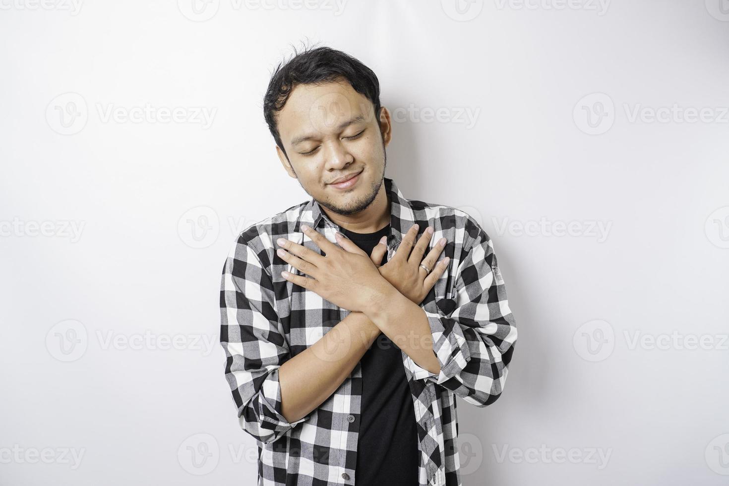 ritratto di un' tranquillo, calmo asiatico uomo indossare tartan camicia è sorridente e sentire sollievo foto