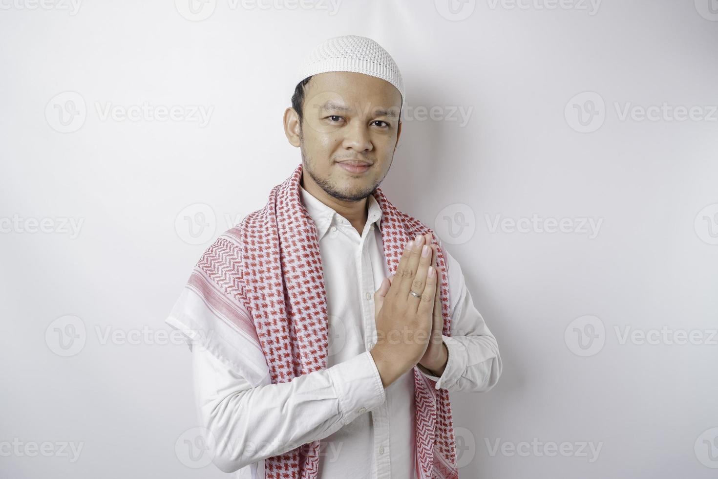 sorridente giovane asiatico musulmano uomo, Esprimere a gesti tradizionale saluto isolato al di sopra di bianca sfondo foto