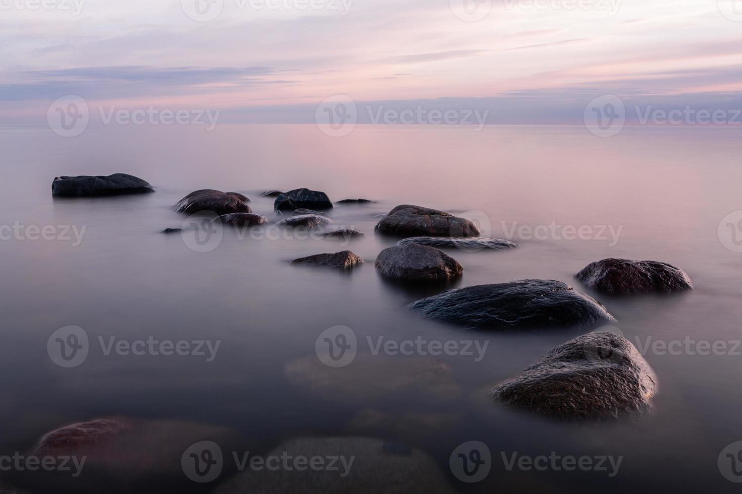 pietre su il costa di il baltico mare a tramonto foto