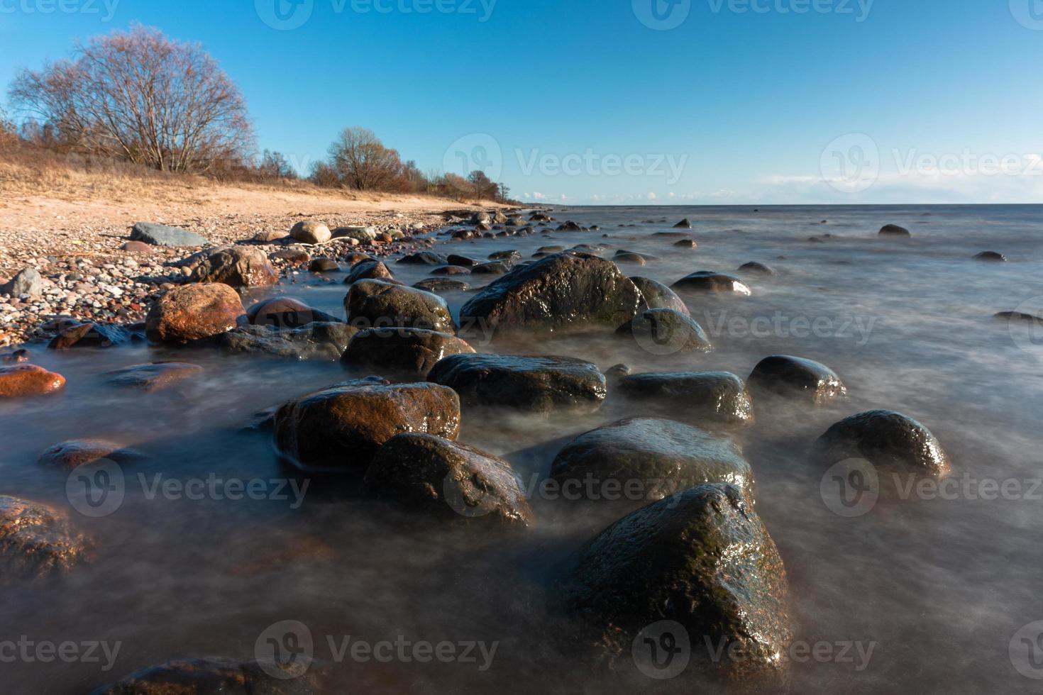 pietre su il costa di il baltico mare a tramonto foto